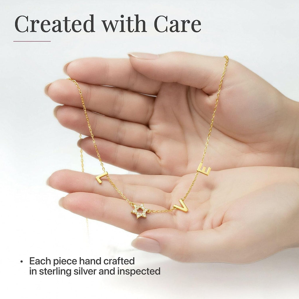 LOVE WITH A JEWISH STAR IN GOLD: The word LOVE is spelled out in warm yellow gold script letter charms where the letter O is replaced by a Star of David set with cubic zirconia, a clever and beautiful